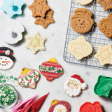 Decorated Christmas cookies on a wire cooling rack. Some are complete with colored icing and others are not.