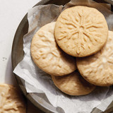 Chai spiced round cookies with stamped snowflake image on top.