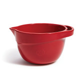 Red Emile Henry bowl with spout and handle at the rim.