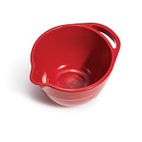 Red Emile Henry bowl with spout and handle at the rim. The angle of the image is looking down into the bowl