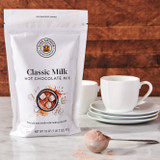 Classic Milk Hot Chocolate Mix package with a scoop of Classic Milk Hot Chocolate Mix and mugs