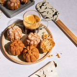Pumpkin cakes made in the pumpkin cakelette pan. Spooky Bats Spatula is to the side., image opens a dialog.