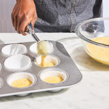 Cupcake batter being added to cupcake papers in pan using Deluxe 4 Tablespoon Scoop