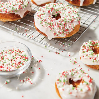 Buttermilk doughnuts with white icing and jingle pop sprinkles - red, green, and white - on top.