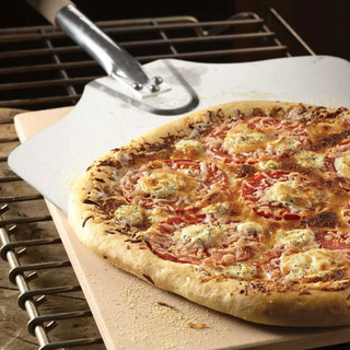 Baker's Peel removing pizza from an oven and pizza stone