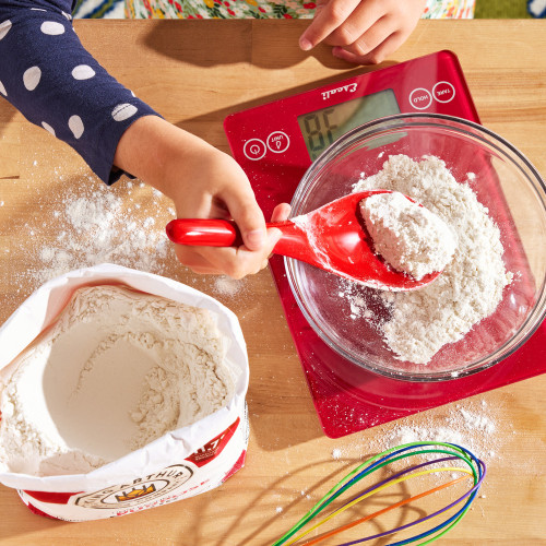 Flour Scoop being used to scoop flour on a scale.