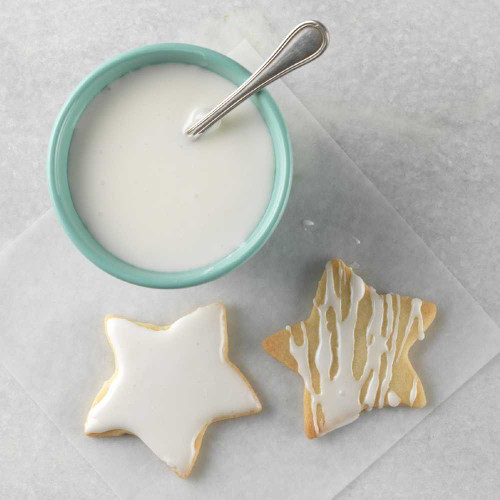 White Icing Mix in a bowl with iced star cookies