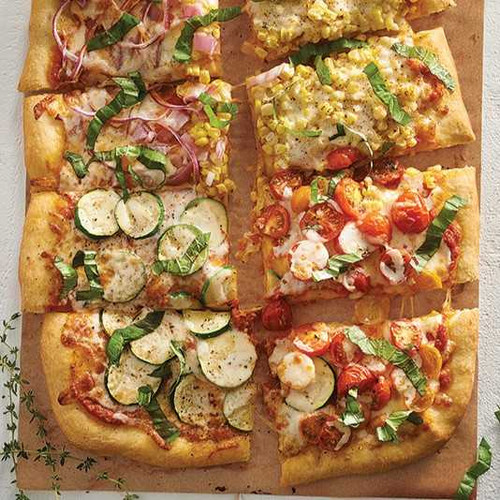 The Easiest Pizza You'll Ever Make recipe. Pizza slices with different toppings - tomatoes, zucchini, corn, cheese, basil, onion.