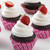 Chocolate cupcakes with vanilla frosting, topped with a strawberry made with Deliciously Simple Chocolate Cake Mix