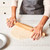Baker using a rolling pin to roll dough on King Arthur Rolling Mat