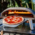 Ooni Koda 16 Pizza Oven with pizza going in the oven.