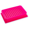 Bright pink plastic 96-well PCR cold work rack viewed from an elevated angle on a white surface.