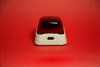 Labnet mini microcentrifuge with white base and transparent red lid on red background.