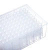 Angled view of a transparent 96-well deepwell plate filled with conical-bottom tips in a plastic storage rack.