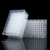 Two transparent plastic 96-well deepwell plates on a reflective black surface.