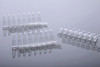 Clear plastic 0.2 mL PCR 8-strip tubes with attached caps, shown in a studio reflection shot.