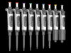 An array of nine 4E's fully autoclavable single-channel adjustable volume pipettes in various sizes and colors against a