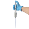 Gloved hand holding a white 4E's Precipette single-channel pipette with a clear tip.