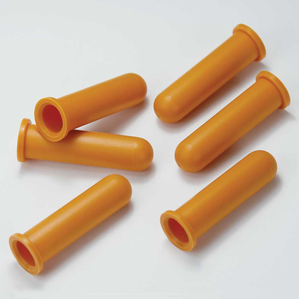 Six orange plastic tube adaptors scattered on a white surface, each featuring a flanged open end and a closed rounded tip.