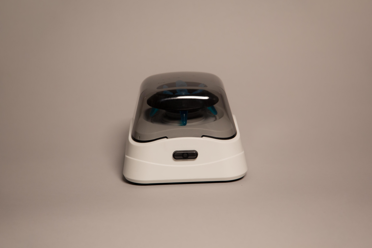 Front view of a Labnet mini microcentrifuge with a gray translucent lid and a blue rotor inside, set against a plain