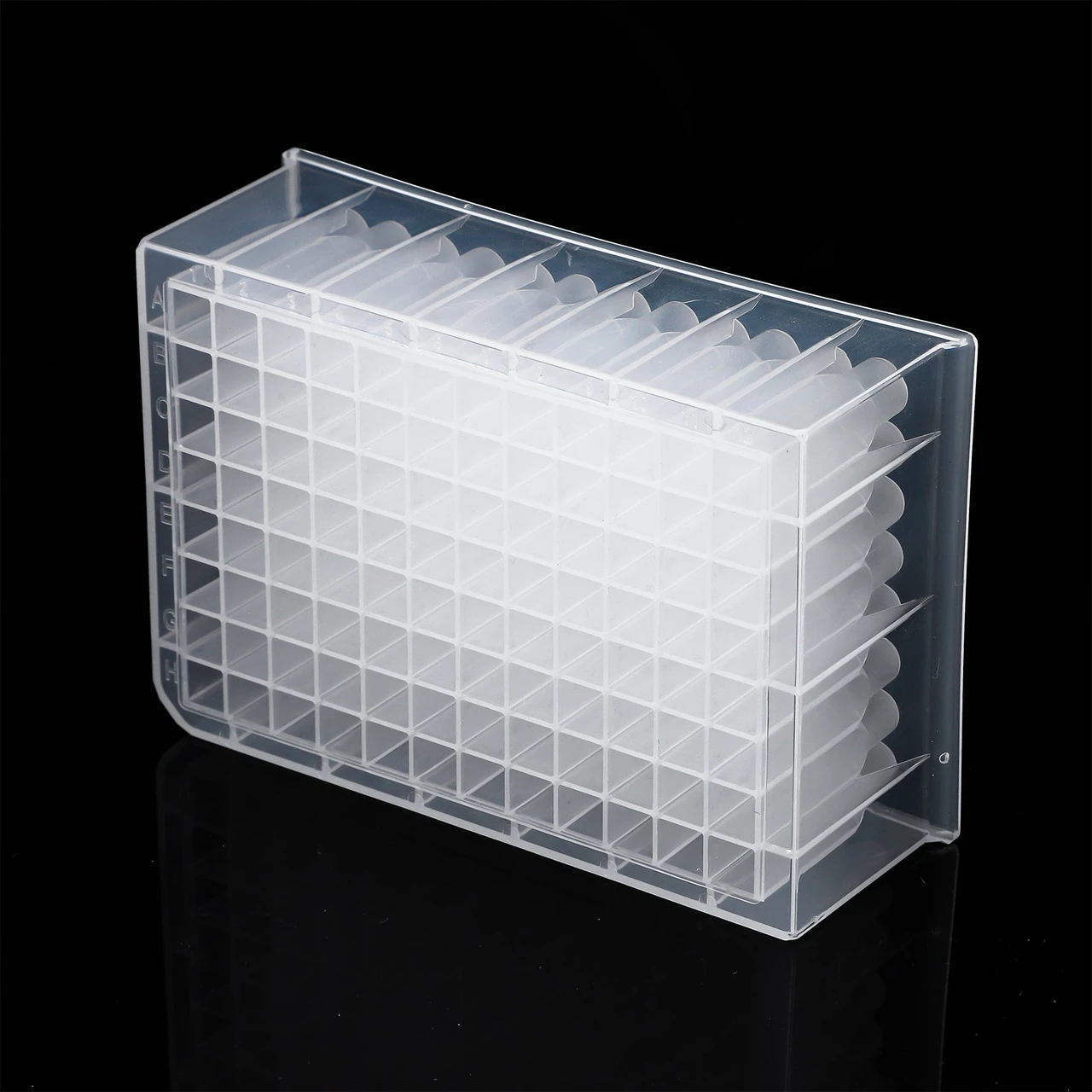 Angle view of a transparent 96 deepwell plate made of polypropylene on a black surface.