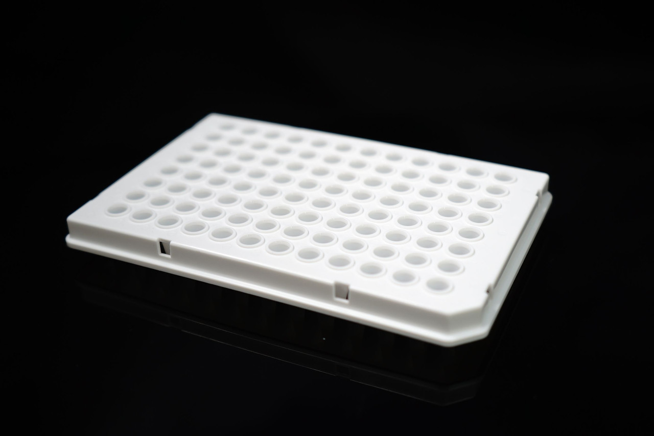 Angle view of a white semi-skirted 96-well PCR plate on a black reflective surface.