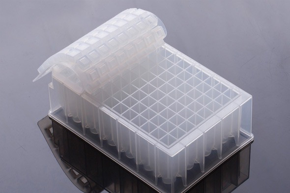 Clear 96-well square deep well plate with a partially peeled flexible silicone sealing mat.