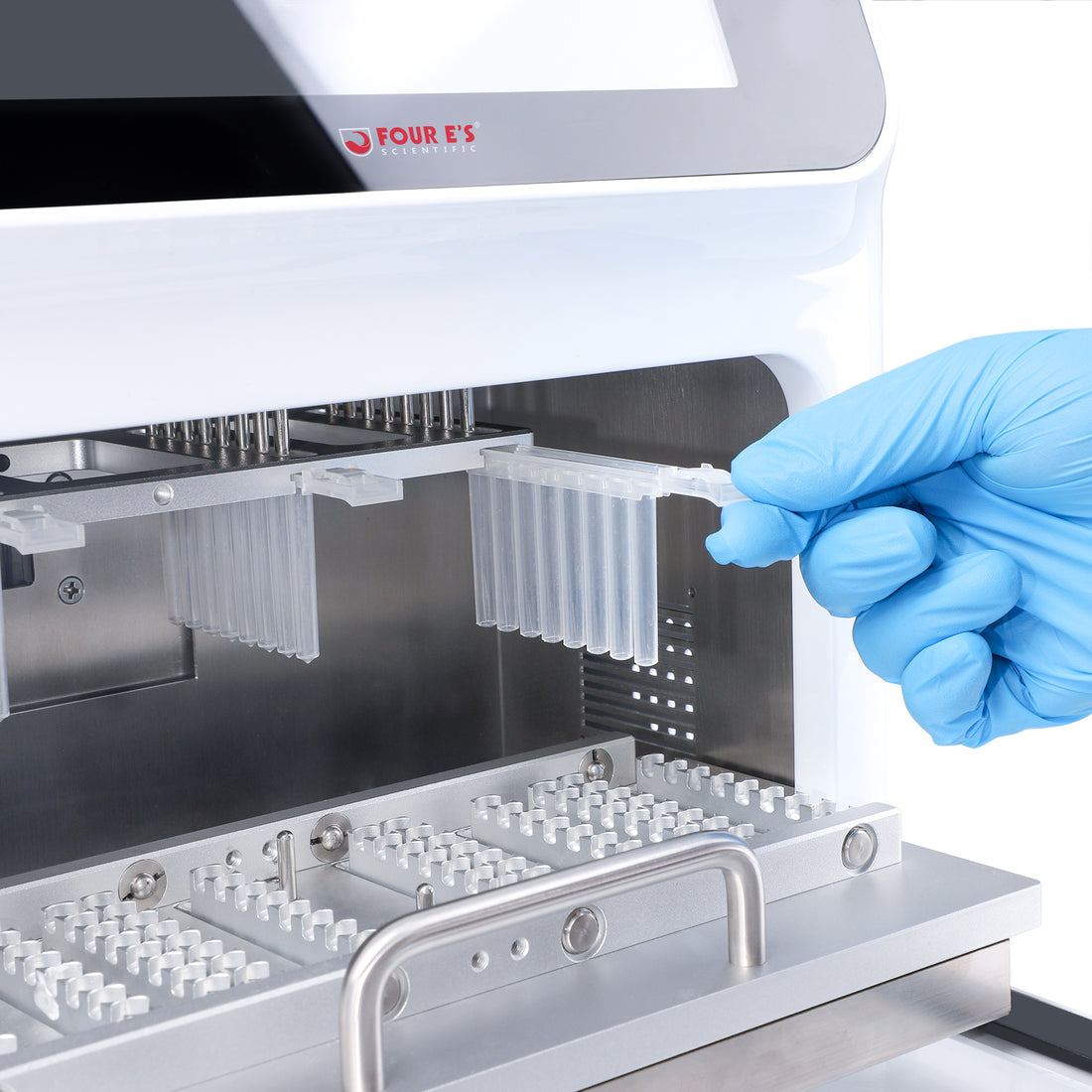 Gloved hand inserting a plastic sample strip into the open chamber of a 4E's nucleic acid extractor.