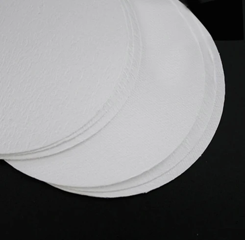A stack of white, round MCE membrane filters viewed from a high angle.