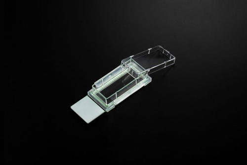 NEST clear single-well cell culture chamber slide with glass base and hinged lid on dark background.
