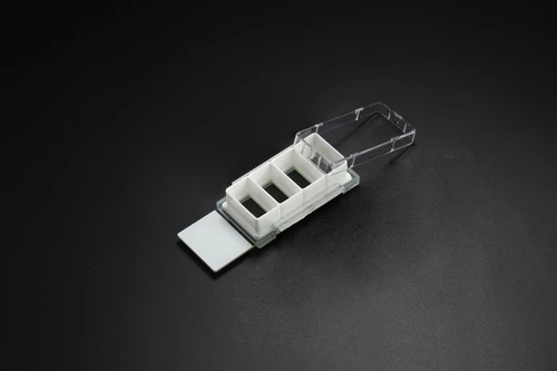 NEST 4-well cell culture chamber slide with white wells and a partially open clear lid.