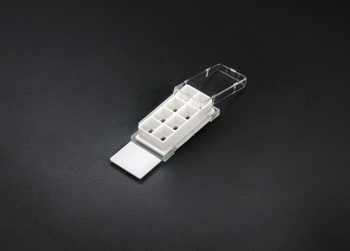 Nest 8-well cell culture chamber slide with a white plastic grid, clear lid, and glass slide base.