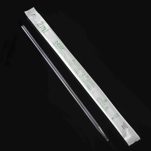 An individually wrapped 2ml NEST aspirating pipette with a clear plastic tube lying next to it on a black background.