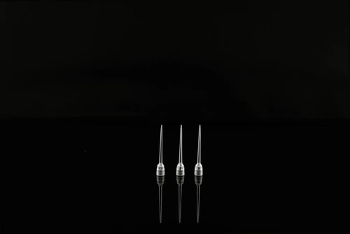 Three clear plastic 50uL robotic filter tips standing upright against a black background with reflections.