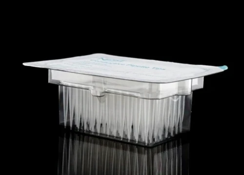 A sealed pack of sterile clear robotic pipette tips in a plastic box on a black surface.