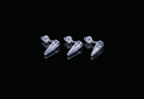 Three clear, plastic 0.2ml PCR tubes with attached flat caps lying horizontally on a black surface.