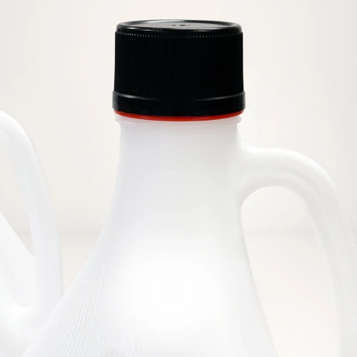 Close-up of a white plastic chemical jug with a black screw cap and red safety ring.