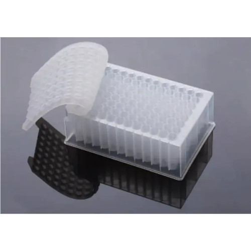 A NEST Scientific 96-well round well silicone sealing mat partially covering a deep well plate on a reflective grey surface.