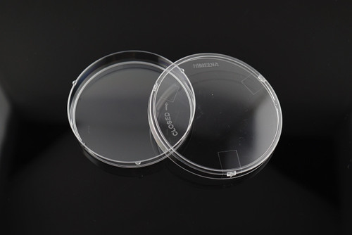Two clear polystyrene petri dishes with safety locks on a reflective black surface.