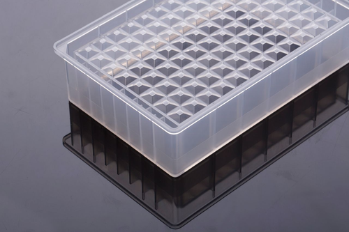 Translucent polypropylene 96-well reservoir microplate viewed from an elevated angle on a reflective surface.