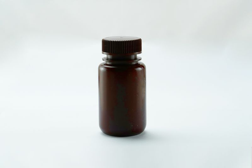 An amber HDPE storage bottle with a wide mouth and ribbed cap on a white background.