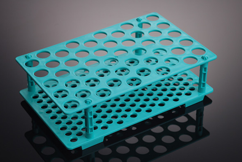 Teal plastic centrifuge tube rack with multiple circular holes for tubes, angled perspective.