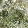 stunning 5x macro view of highly translucent, bottle-green atomic glass with a swarm of trapped gas bubbles, metal, minor red, Sciencemall