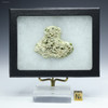Back-facing larger green, black, minor red, metal-bearing  trinitite atomic glass ID: 721187 in a Riker box, Science Mall-USA