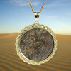 NWA 869 meteorite coin mount jewelry 14k gold show on a chain with a blue sky and dark red sand background, at Sciencemall-USA NWA 869 meteorite coin mount jewelry 14k gold show on a chain with a blue sky and dark red sand background, at Sciencemall-USA