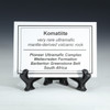 Description tag for komatiites from the Pioneer Ultramafic Complex for sale at Sciencemall USA. This tag is shown on a black tag stand.