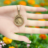 Ouroboros jewelry necklace with gold chain shown with a centered stromatolite [63807] in a hand.