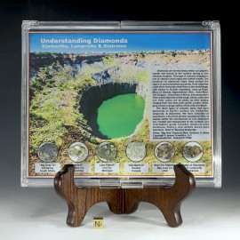 Diamond gem rock collection that includes kimberlite, lamproite and diatreme displayed in a plexiglass case on a stand with sizing cube.