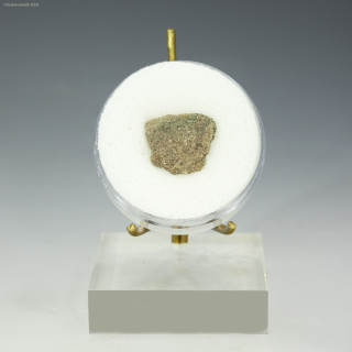 Front-facing-trinitite green, minor black, with metal shown in a disk on a display stand at Sciencemall-USA Front-facing-trinitite green, minor black, with metal shown in a disk on a display stand at Sciencemall-USA