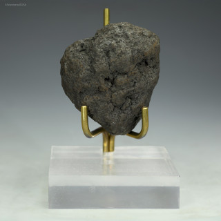 Manganese nodule 69 grams Clarion-Clipperton Pacific Ocean, facing front on a plexiglass riser, at Sciencemall-USA
